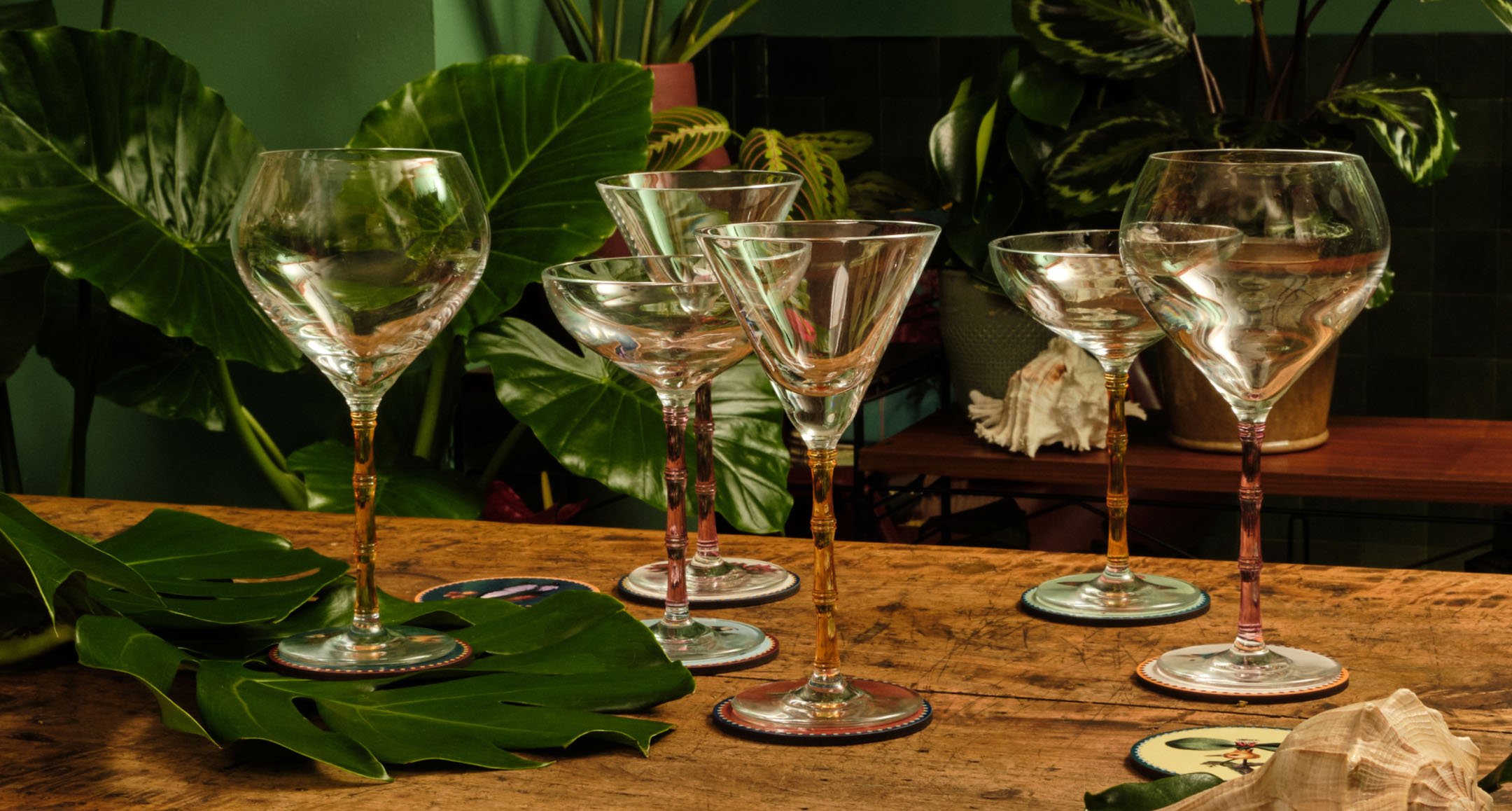 Bamboo-style glassware on a green backdrop, softly lit